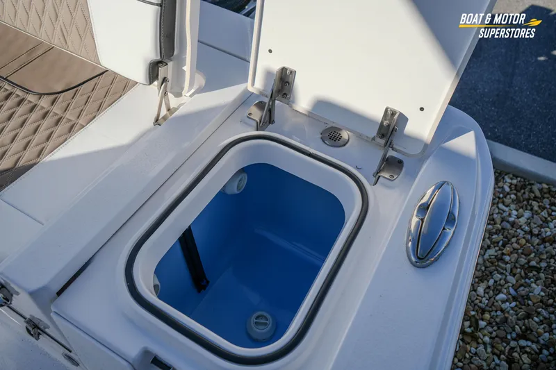 Slide: The Image of Open storage compartment on 2025 Blackfin 242 HB boat, featuring blue interior and stainless steel handle. - 51