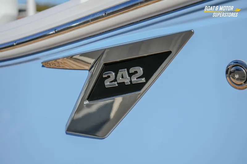 Slide: The Image of Close-up of 2025 Blackfin 242 HB boat emblem on light blue hull. - 8