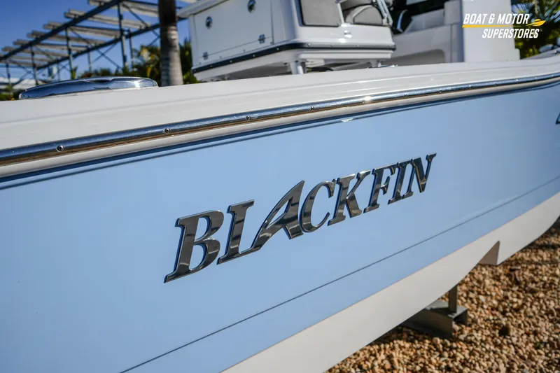 Slide: The Image of 2025 Blackfin 242 HB boat side view with logo, displayed at a dealership. - 9