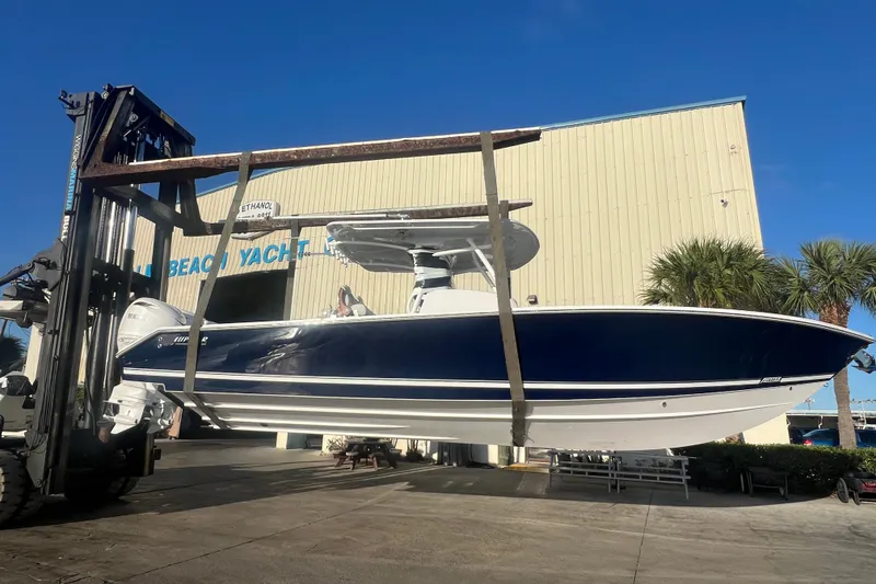Slide: The Image of 2026 Jupiter 32 boat lifted by forklift at marina, clear blue sky. - 5