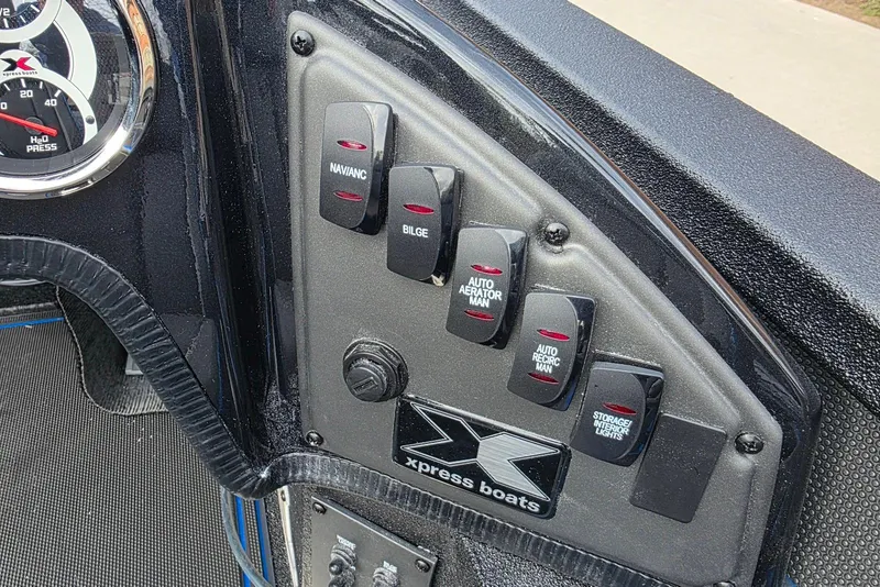 Slide: The Image of Control panel of 2026 Xpress X21 Pro boat with various switches and gauges. - 18