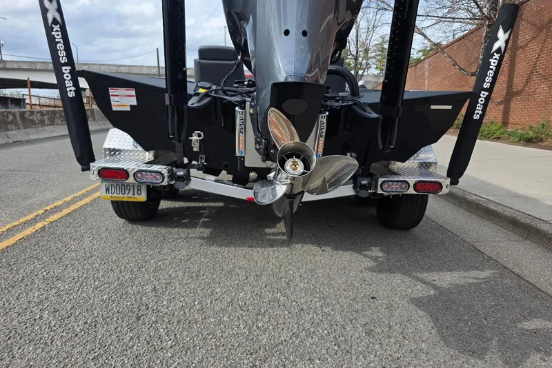 Slide: The Image of Rear view of 2026 Xpress X21 Pro boat on trailer, showing propeller and license plate. - 21