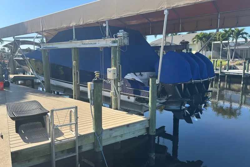 Slide: The Image of 2024 Nor-Tech 400 Supersport boat docked with blue covers, under a canopy. - 25