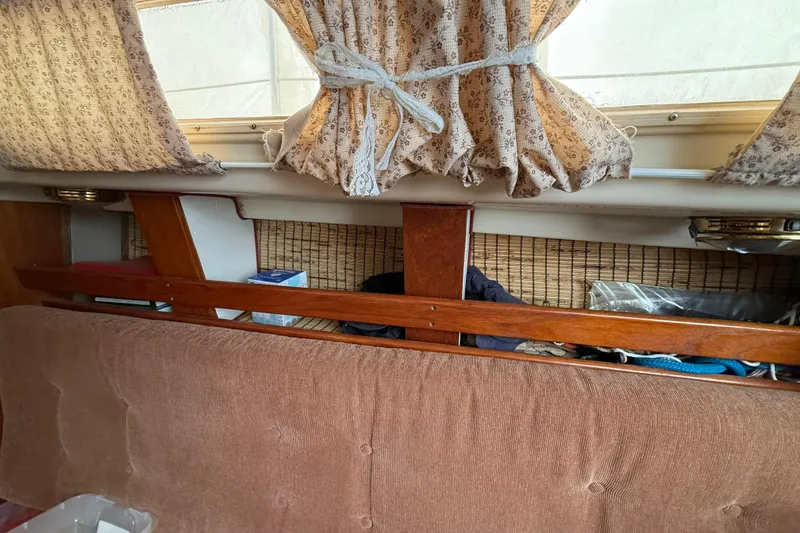 Slide: The Image of Interior of a 1979 O'Day 37 sailboat with patterned curtains and wooden accents. - 13