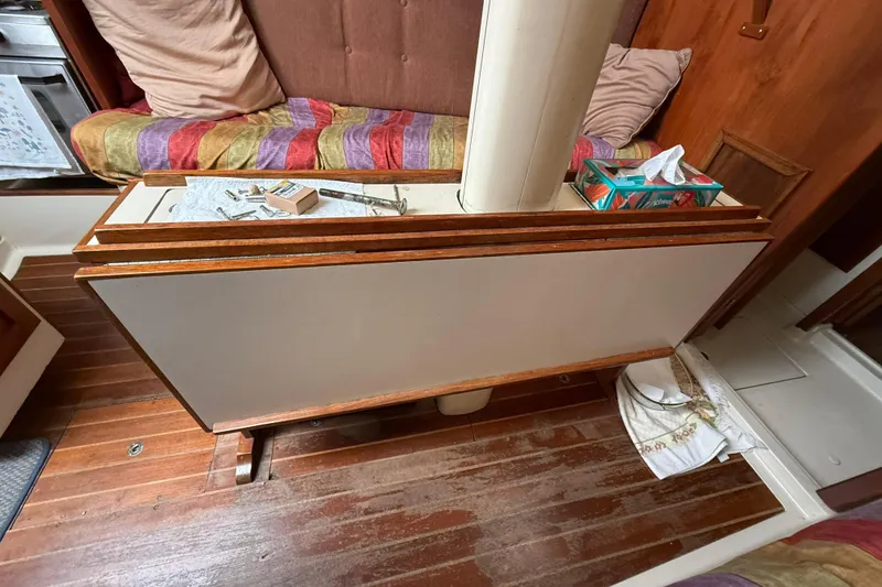 Slide: The Image of Interior of a 1979 O'Day 37 sailboat with wooden flooring and seating area. - 15