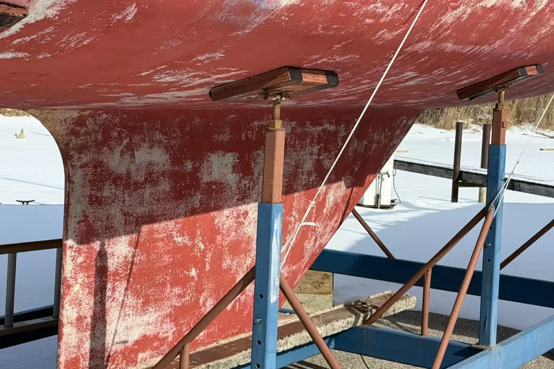 Slide: The Image of 1979 O'Day 37 sailboat keel on stands, showing weathered red paint. - 25