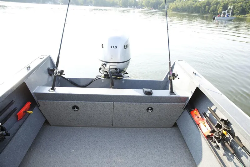 Slide: The Image of 2026 Smoker Craft Phantom 20 X2 boat interior with fishing rods and Honda motor on a lake. - 3
