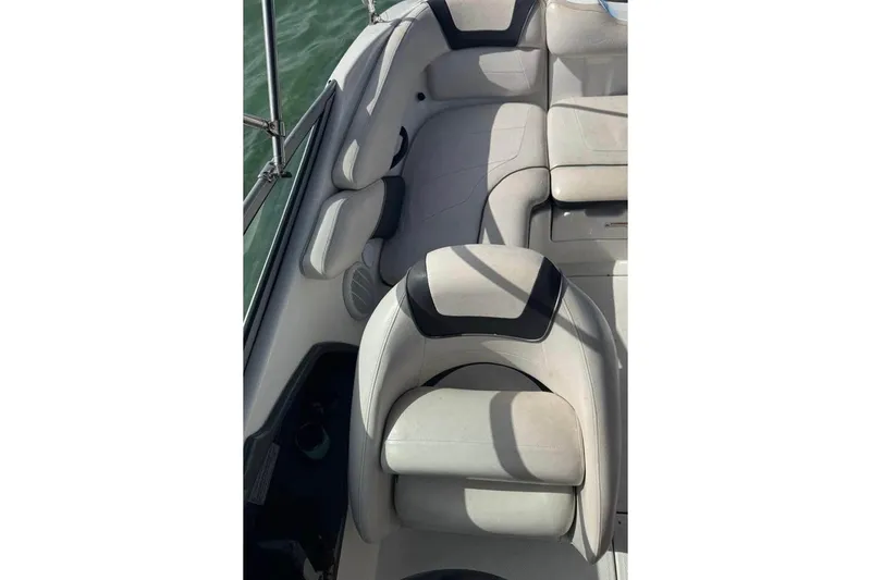 Slide: The Image of 2012 Yamaha Boats SX190 interior with seating and steering, docked near other boats. - 10