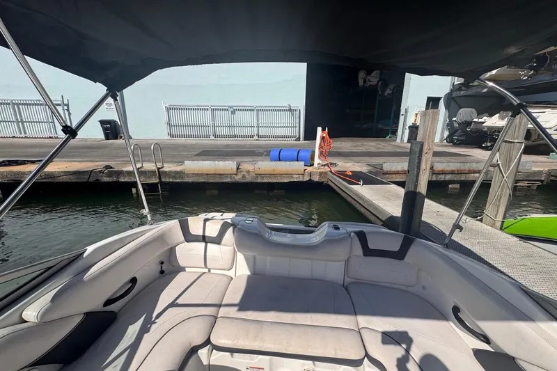 Slide: The Image of 2012 Yamaha Boats SX190 docked, featuring spacious seating and canopy, at a marina. - 15