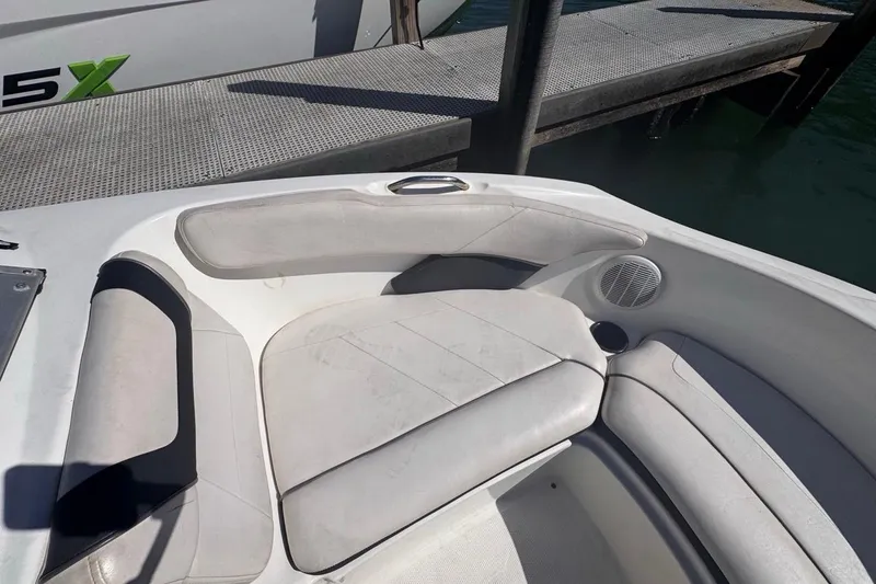 Slide: The Image of 2012 Yamaha Boats SX190 interior seating near dock, featuring white cushioned seats. - 27