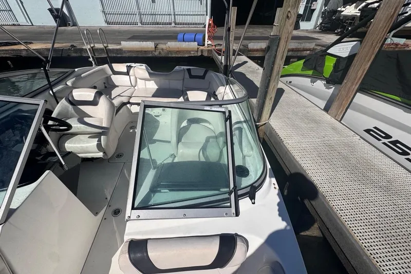 Slide: The Image of 2012 Yamaha Boats SX190 with white seating, docked beside a pier. - 31