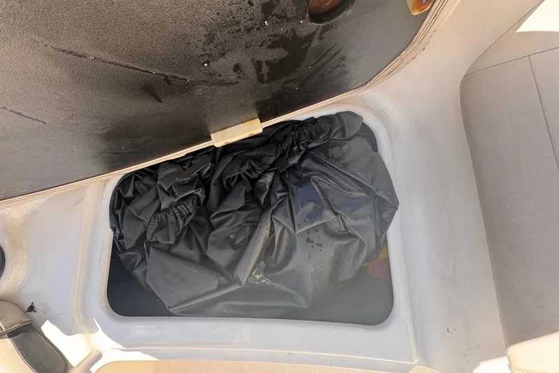 Slide: The Image of Storage compartment in a 2012 Yamaha SX190 boat with black cover inside. - 34
