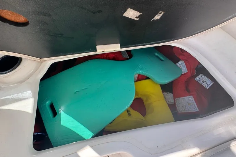 Slide: The Image of Storage compartment of 2012 Yamaha SX190 boat with life jackets and a green float. - 35