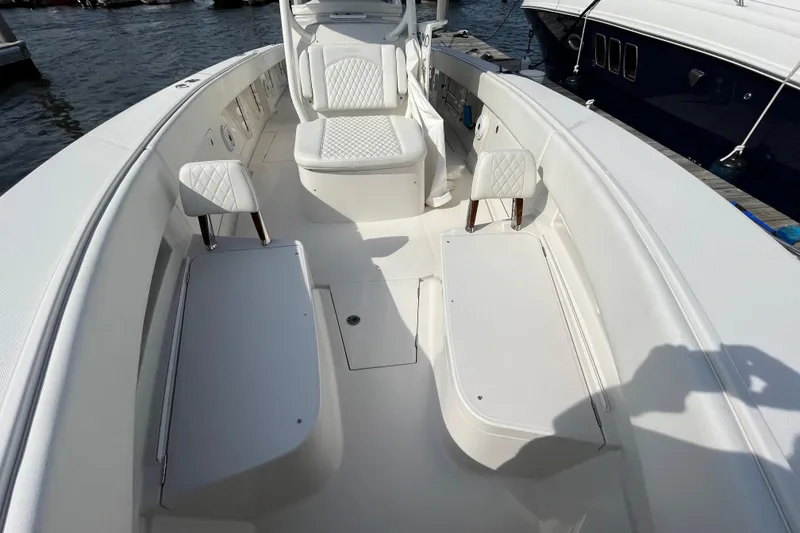 Slide: The Image of 2020 Jupiter 34 Center Console boat interior with white seating and storage compartments. - 15
