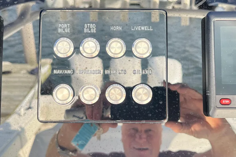 Slide: The Image of Control panel of a 2020 Jupiter 34 Center Console boat with various labeled buttons. - 28