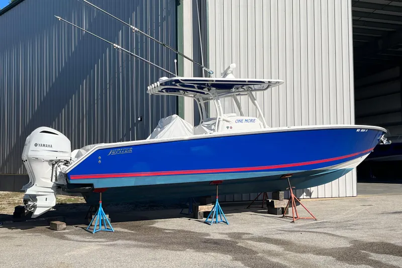 Slide: The Image of 2020 Jupiter 34 Center Console boat with Yamaha engines, displayed on stands outside a building. - 3