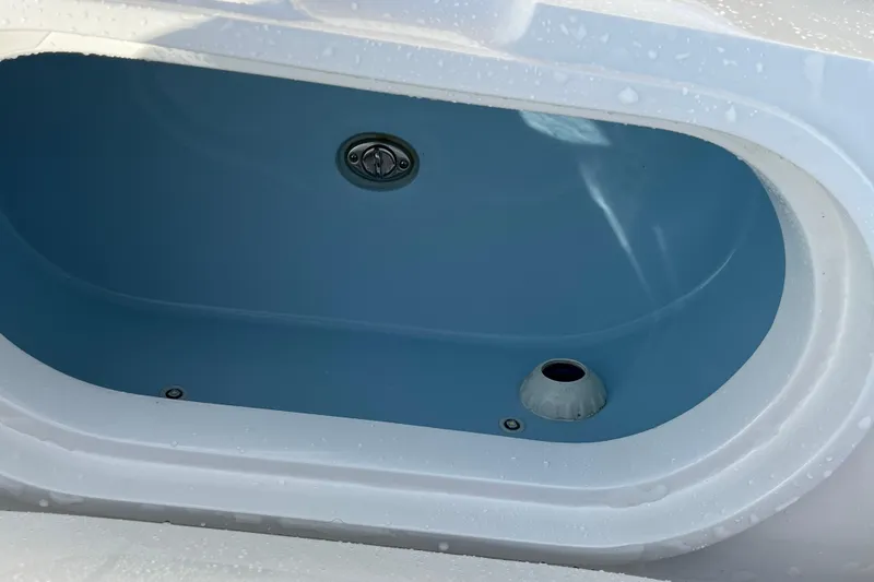 Slide: The Image of Livewell compartment on a 2020 Jupiter 34 Center Console boat, featuring a blue interior. - 38