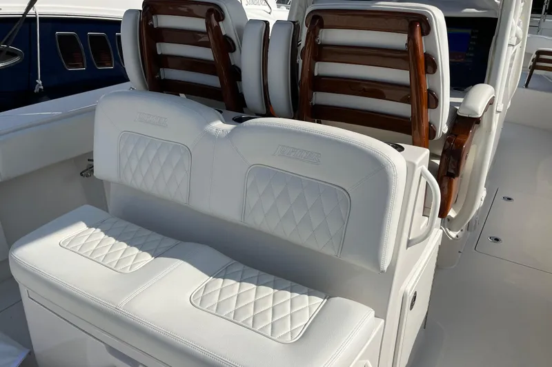 Slide: The Image of 2020 Jupiter 34 Center Console boat with white cushioned seating and wooden accents. - 39