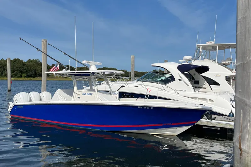 Slide: The Image of 2020 Jupiter 34 Center Console boat docked, blue hull, white interior, sunny day. - 4
