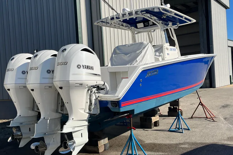 Slide: The Image of 2020 Jupiter 34 Center Console boat with triple Yamaha 300 engines, blue hull, on stands. - 8
