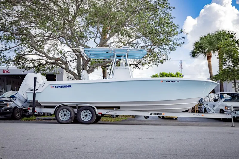 Slide: The Image of 2024 Contender 28 Tournament boat on trailer, parked outdoors, with trees and vehicles in the background. - 10