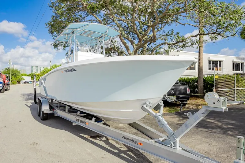 Slide: The Image of 2024 Contender 28 Tournament boat on trailer, parked outdoors under a clear blue sky. - 12
