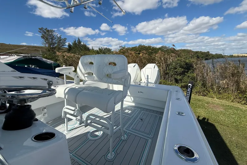 Slide: The Image of 2024 Contender 28 Tournament boat with white seating, docked near a scenic riverbank. - 31