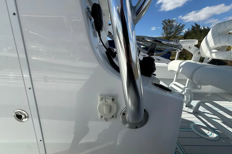 Slide: The Image of 2024 Contender 28 Tournament boat interior with steering wheel and seating, under a clear blue sky. - 32