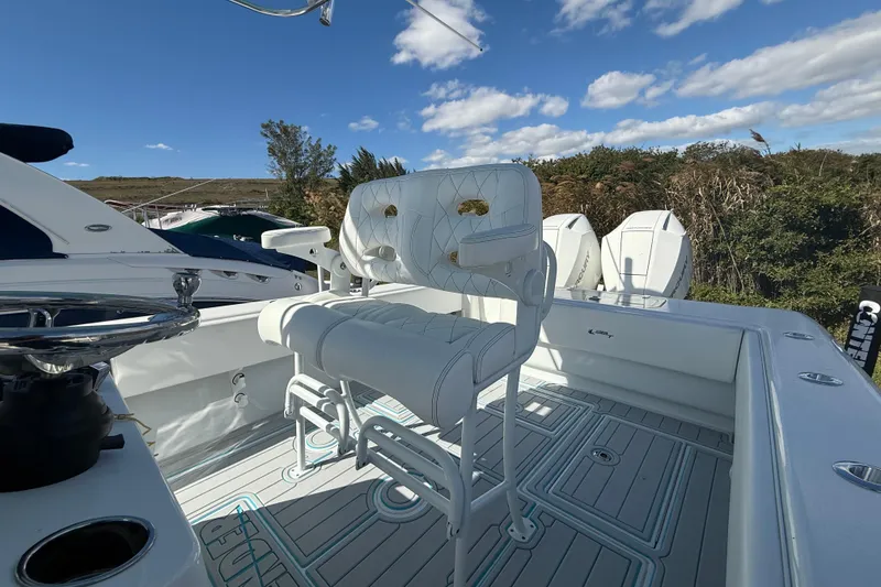 Slide: The Image of 2024 Contender 28 Tournament boat with white seating and dual outboard motors. - 7