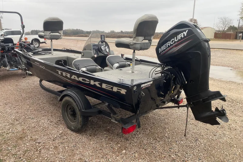Slide: The Image of 2018 Tracker Pro 160 boat with Mercury outboard motor on a gravel surface. - 4