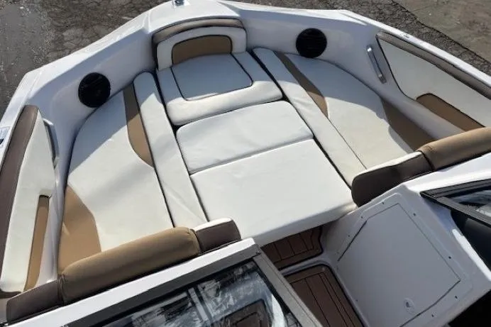 Slide: The Image of 2023 Yamaha Boats 195S interior with white and tan seating, spacious and luxurious design. - 10