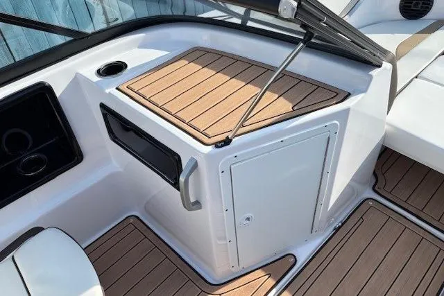 Slide: The Image of 2023 Yamaha Boats 195S interior with wood accents and storage compartment. - 11