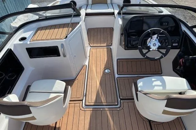 Slide: The Image of 2023 Yamaha Boats 195S interior with sleek design and wood finish flooring. - 13