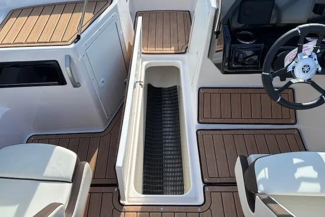Slide: The Image of 2023 Yamaha Boats 195S interior with wood accents and storage compartment. - 14