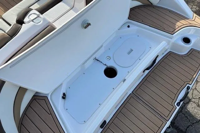 Slide: The Image of 2023 Yamaha Boats 195S storage compartment with teak-style flooring and seating area. - 30