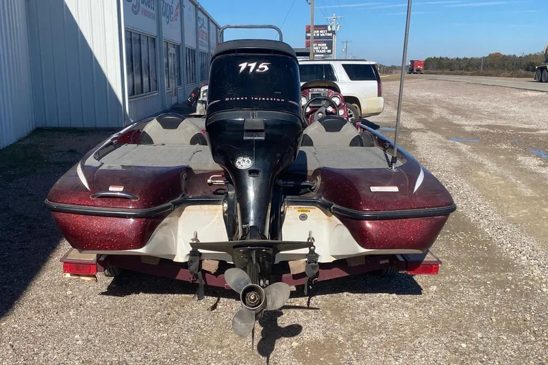 Slide: The Image of 2009 Nitro X-5 boat with outboard motor, parked on gravel near a building. - 5