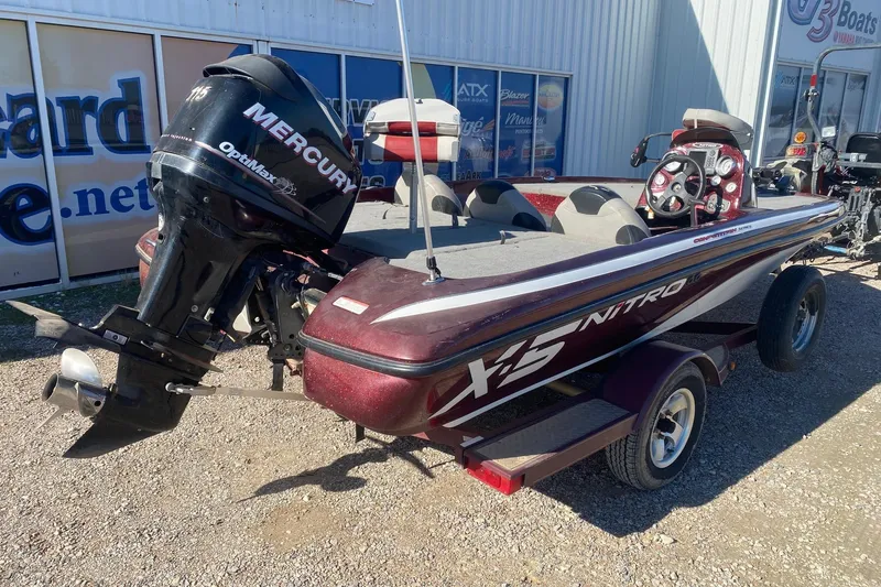 Slide: The Image of 2009 Nitro X-5 boat with Mercury OptiMax engine, parked outdoors. - 6