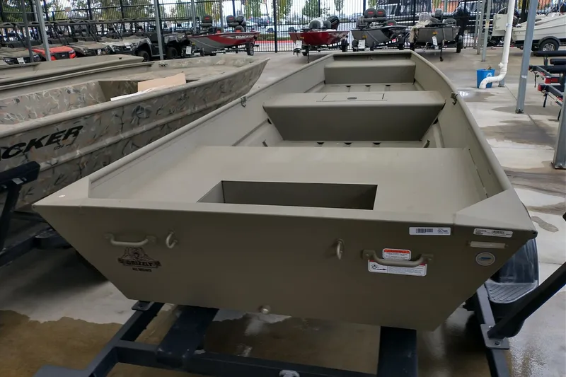 Slide: The Image of 2026 Tracker Grizzly 15 Jon boat displayed in a showroom, showcasing its sturdy design. - 3