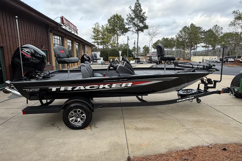The Image of 2026 Tracker Pro Team 195 boat on trailer, parked outside a boat service shop. - 0