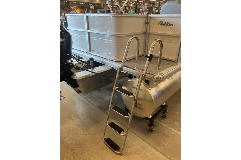 Slide: The Image of 2026 Sun Tracker Party Barge 18 DLX pontoon boat with ladder and motor, indoor display. - 2