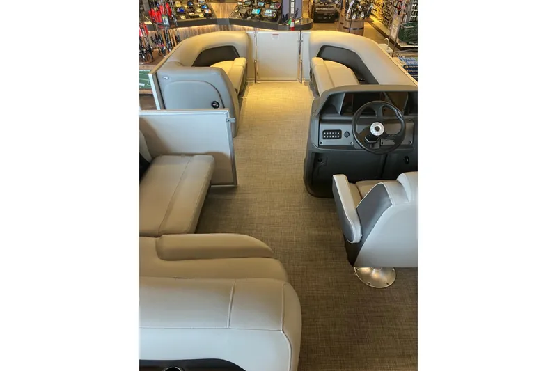 Slide: The Image of Interior of 2026 Sun Tracker Party Barge 18 DLX with plush seating and steering console. - 10