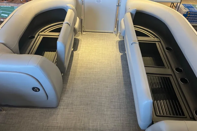 Slide: The Image of 2026 Sun Tracker Party Barge 18 DLX interior with gray seating and cup holders. - 6
