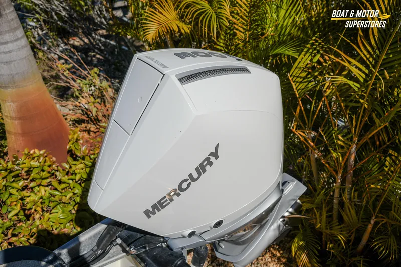 Slide: The Image of 2024 Avalon Twin Quad Lounger Windshield with Mercury outboard motor, surrounded by lush greenery. - 19