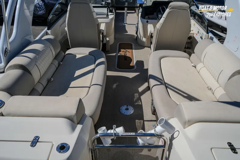 Slide: The Image of 2024 Avalon Twin Quad Lounger Windshield boat interior with beige seating and steering console. - 20