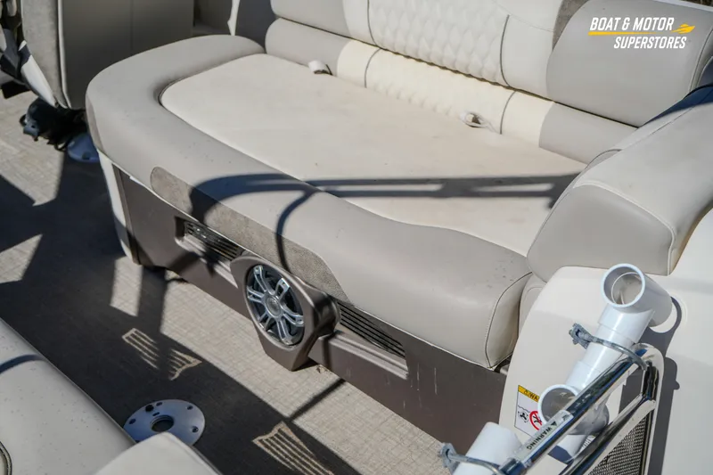 Slide: The Image of 2024 Avalon Twin Quad Lounger Windshield boat interior with beige seating and speaker system. - 23