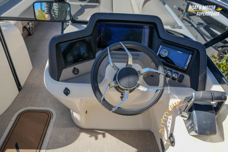 Slide: The Image of 2024 Avalon Twin Quad Lounger Windshield boat dashboard with steering wheel and controls. - 26