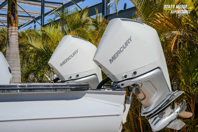 Slide: The Image of 2024 Avalon Twin Quad Lounger with Mercury outboard motors, surrounded by tropical foliage. - 4