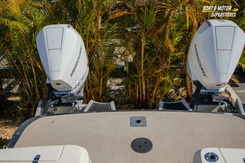 Slide: The Image of 2024 Avalon Twin Quad Lounger boat with dual Mercury outboard motors, surrounded by lush greenery. - 42