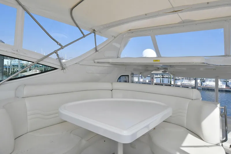 Slide: The Image of 2001 Carver 466 Motor Yacht interior with white seating and table, marina view. - 14