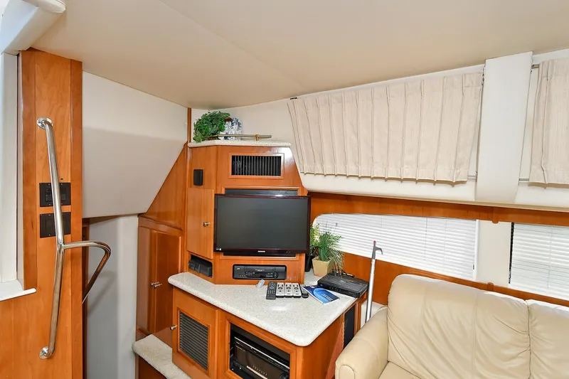 Slide: The Image of Interior of 2001 Carver 466 Motor Yacht with TV, beige sofa, and wooden cabinetry. - 22